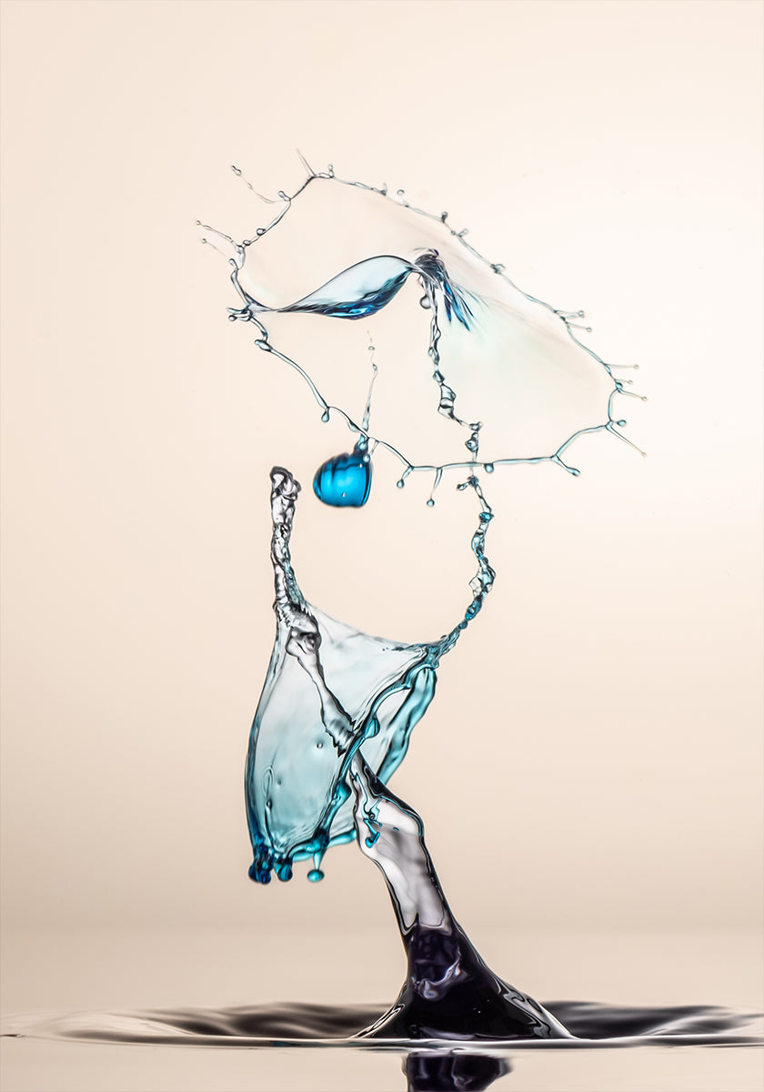 une éclaboussure d'eau dynamique, avec un objet bleu suspendu dans les airs et une grande éclaboussure d'eau tombant en cascade, créant une sensation de mouvement et d'énergie.