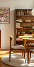 une salle à manger confortable avec une table et des chaises en bois, une étagère et une œuvre d'art encadrée au mur.