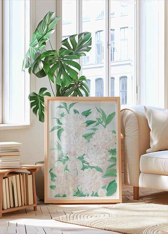 une grande impression encadrée de fleurs blanches avec des feuilles vertes, placée sur un parquet dans une pièce lumineuse et aérée avec de grandes fenêtres.
